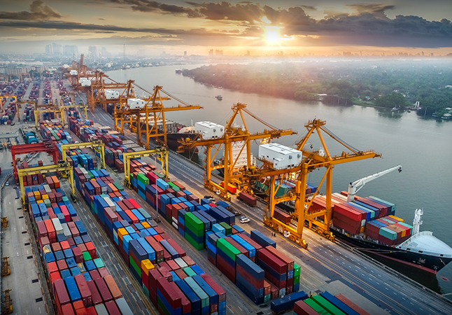 Logistics and transportation of Container Cargo ship and Cargo plane with working crane bridge in shipyard at sunrise, logistic import export and transport industry background